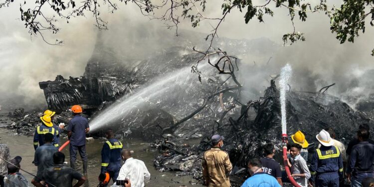 Firefighters are seen in action at the site of an airplane crash in Ahmedabad. Photo by Vijay Soneji.